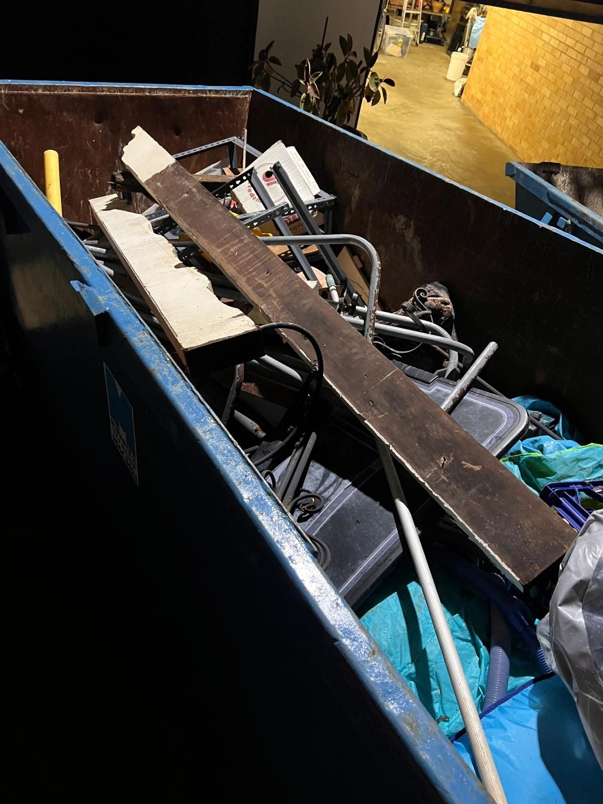 Discarded building materials and debris in skip bin after water damage restoration.