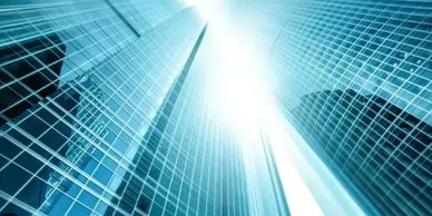 Sunlight reflecting off modern glass skyscrapers in a city.