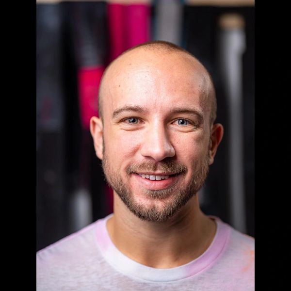 Portrait of a smiling bald man with a beard and blue eyes.