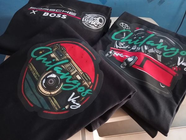 Three black shirts with colorful car-themed graphics and the word 'Chilangos' displayed.