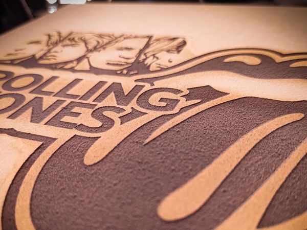 Close-up of Rolling Stones logo engraved on a surface.
