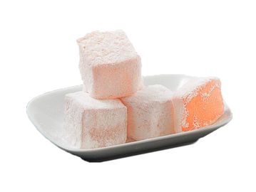 Orange Turkish delight cubes on a white dish.