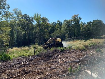 A skidder is used to apply herbicide to a recent clearcut to prepare the site for planting. 