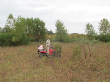 Herbicide is applied from an ATV with a mounted spray tank