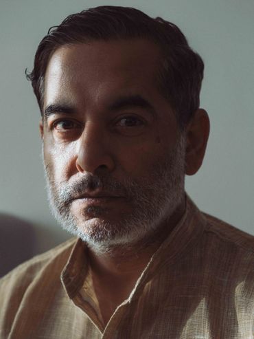 Portrait of a mature man with a beard in soft lighting.