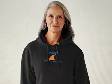 Smiling woman with gray hair wearing a black hoodie with a logo.