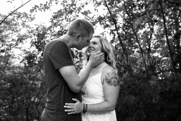 Couple sharing a tender moment in the woods.
