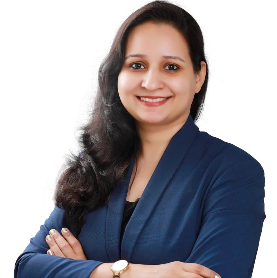 Portrait of a confident woman with long dark hair in a blue blazer.
