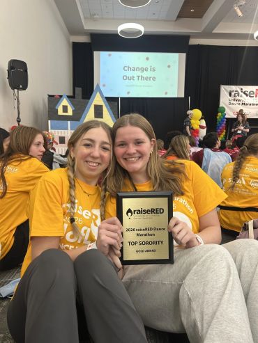 Two young women holding a 2023 raiseRED Dance Marathon award.