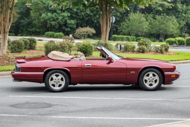 Classic red convertible car parked outdoors.