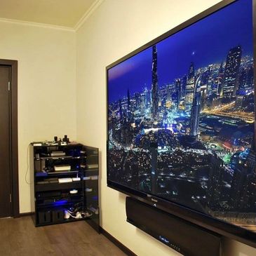 Modern living room with a large TV displaying a city skyline at night.