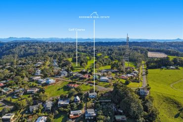 Aerial view of a residential area near a golf course and communication tower.