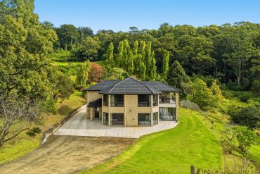 Modern house surrounded by greenery and trees.