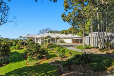 Modern house with garden and driveway on a sunny day.