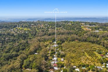 Aerial view of a property surrounded by greenery and trees.