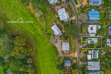 Aerial view of residential properties near a green field.