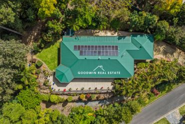 Aerial view of a house with solar panels and green roof.