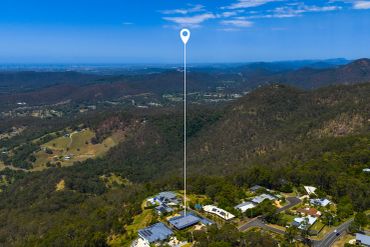 Aerial view of a mountainous residential area with a location pin.