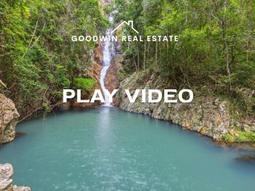 Serene waterfall flowing into a turquoise pool surrounded by lush greenery.