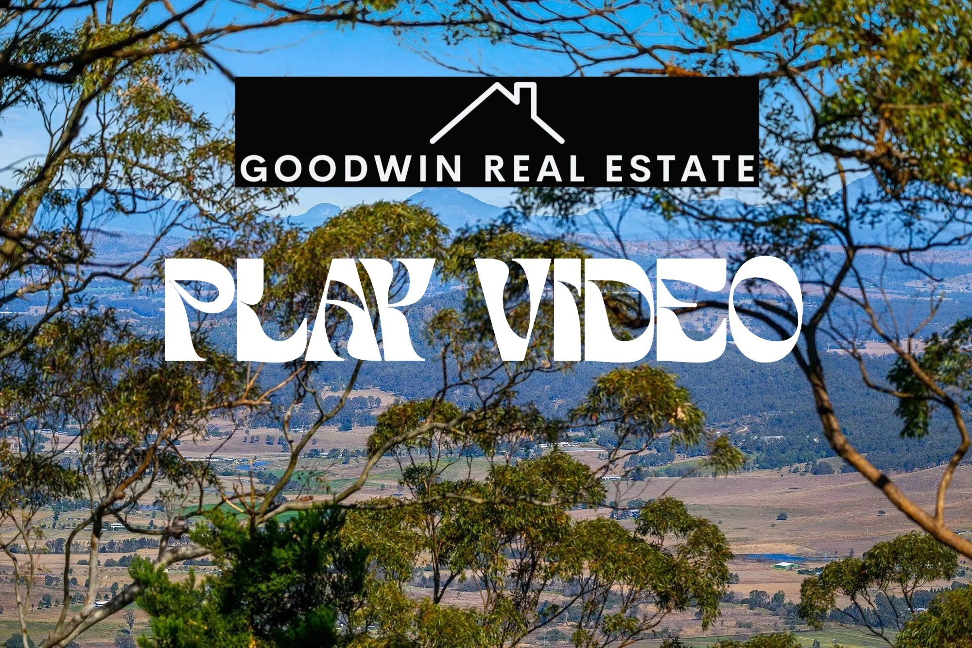 Scenic rural landscape with overlay text promoting Goodwin Real Estate video.