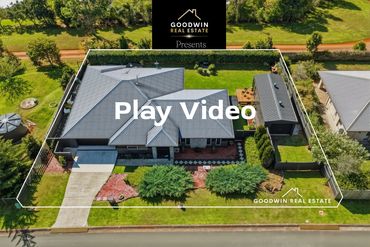 Aerial view of a modern house with a garden and driveway.