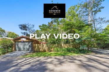 Residential property surrounded by trees and greenery.