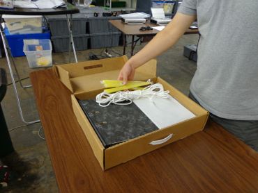 Person unpacking a device from a cardboard box.