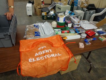 Electoral agent vest and voting supplies on a table.