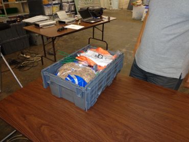 A gray crate with packed items on a table.