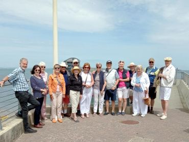Group of people posing by the seaside on a sunny day.