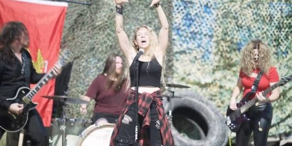 Rock band performing energetically outdoors.