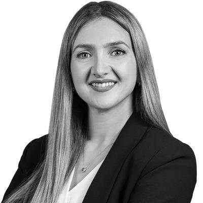 Professional woman smiling confidently with arms crossed.