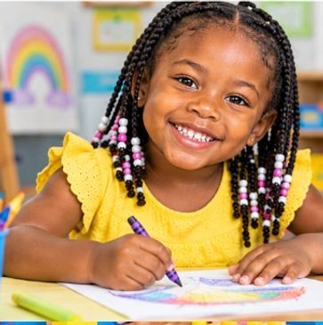 Smiling girl coloring a rainbow picture