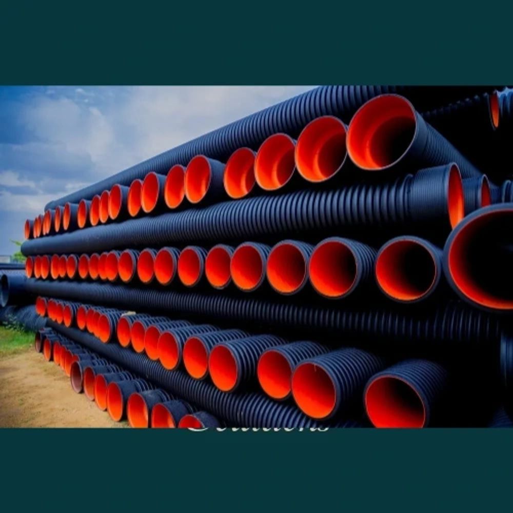Stacked black pipes with bright orange interiors arranged outdoors.