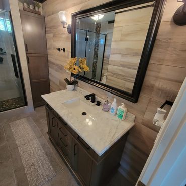 Modern bathroom vanity with marble countertop and large mirror.