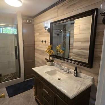 Modern bathroom with marble countertop and glass shower.