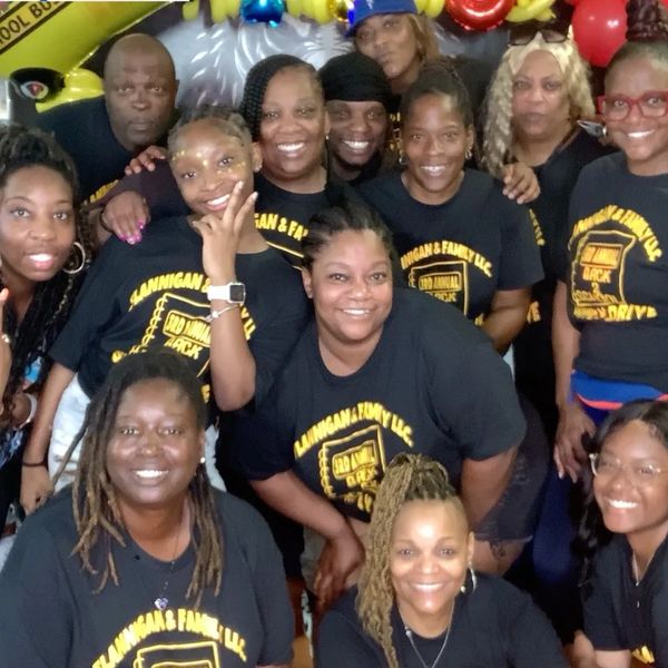 A joyful group wearing matching family reunion T-shirts posing together.
