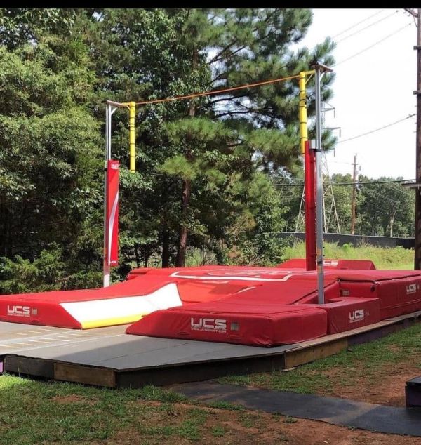 Outdoor high jump setup with padded landing area.