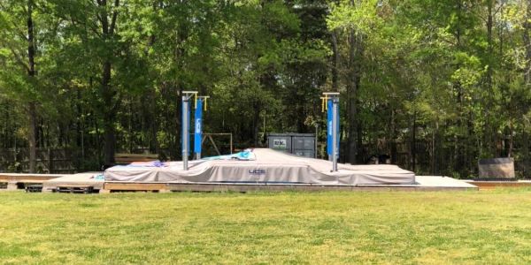 Outdoor pole vault landing area with protective pads.