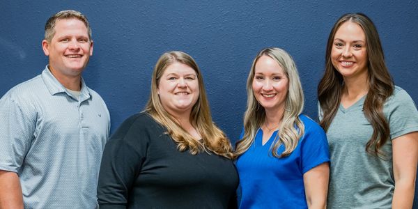 three women and a man posing for a picture 