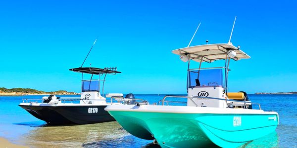 Two Oceanwhaler centerconsole boats beached at Rockingham