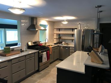 Modern kitchen with stainless steel appliances and gray cabinets.