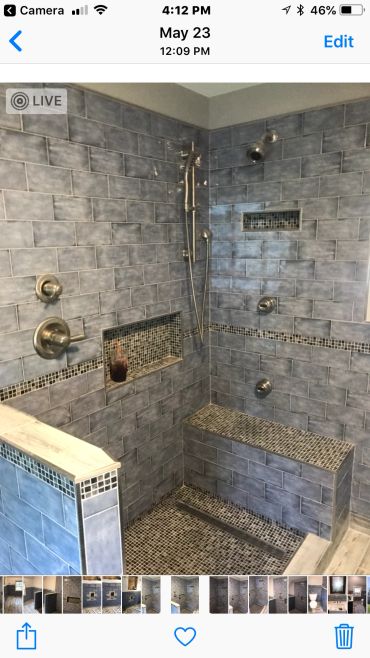 Modern gray tiled shower with built-in bench and niches.