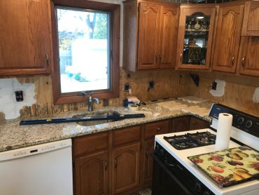 Kitchen undergoing renovation with some cabinets removed.
