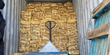 Lumpers palletizing bags of charcoal