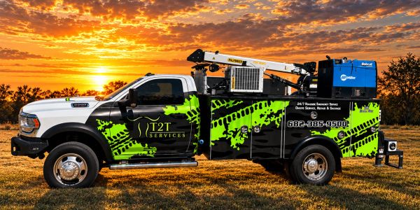 Service truck with green tire tracks design at sunset.