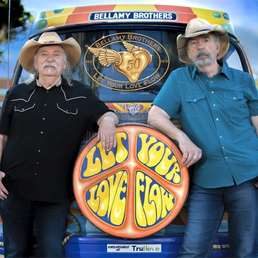 Two older men in cowboy hats posing by a colorful Bellamy Brothers van.