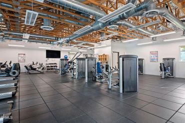 Spacious modern gym with various workout machines and treadmills.
