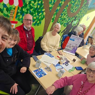 A cheerful group of seniors gathered around a table at a community café.

One of the CAS Café Groups