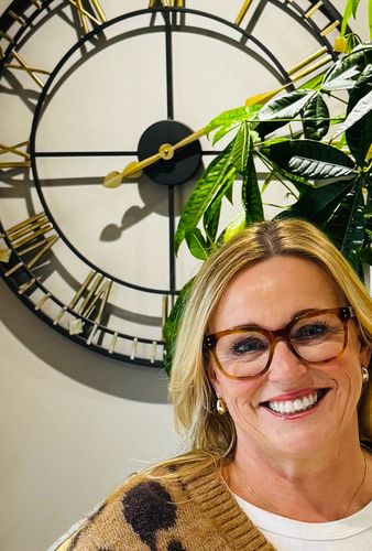 A photo of a lady smiling in her kitchen